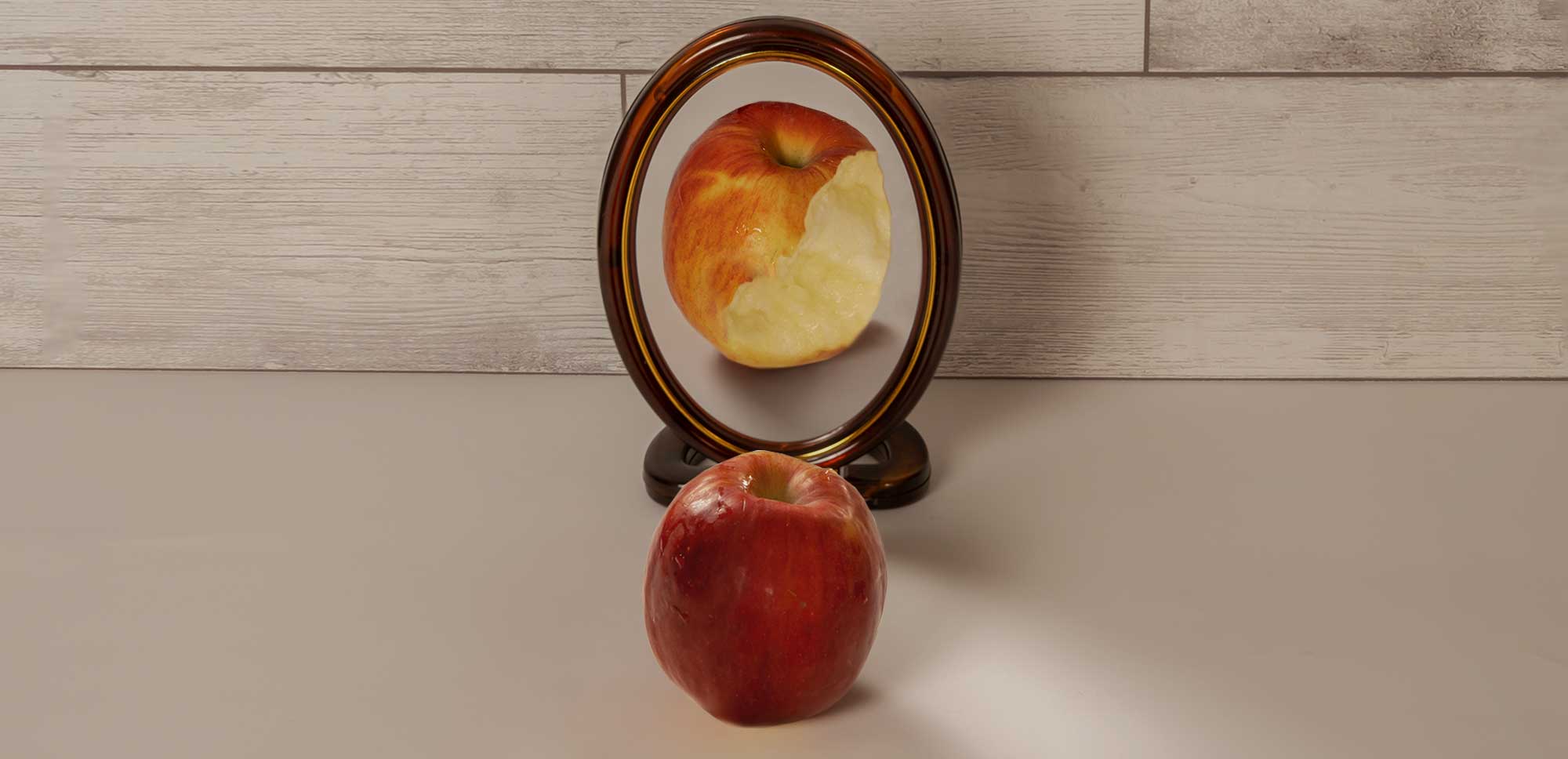 manzana roja mordida frente a espejo