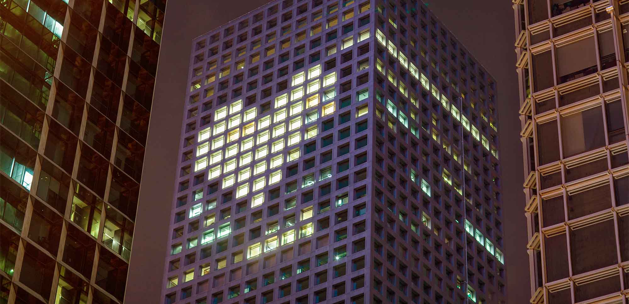 edificio de oficinas de una ciudad con un corazon de luces