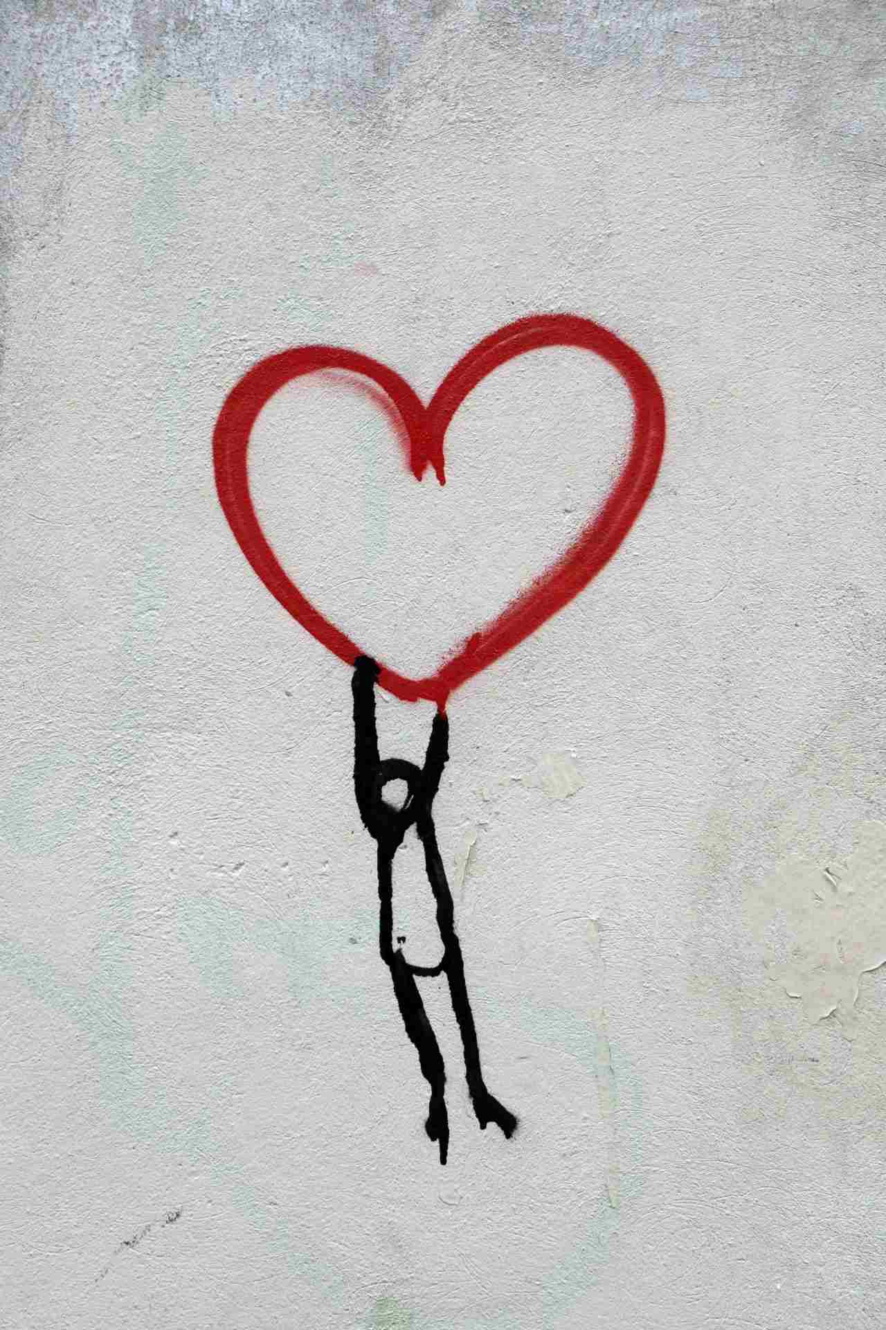 grafiti dibujo persona colgada de un corazon rojo